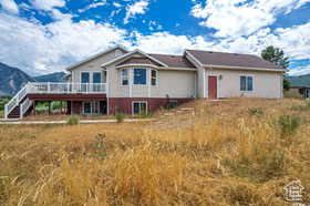 Rear view of house with a wooden deck and stairway