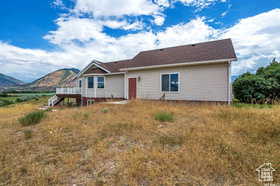 View of front of house with a deck with mountain view and stairs