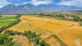 Aerial view of sparsely populated area featuring a mountain backdrop and abundant farmland