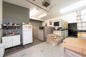 Misc room with a desk, a garage, and concrete flooring