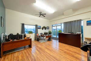 Office space featuring ceiling fan, lofted ceiling, and a textured ceiling