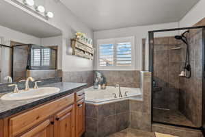 Full bathroom featuring vanity, a garden tub, a shower stall, and tile patterned flooring