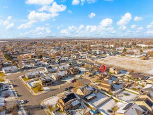 Aerial view of property and surrounding area featuring nearby suburban area and a mountain backdrop