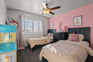 Carpeted bedroom with lofted ceiling and a ceiling fan