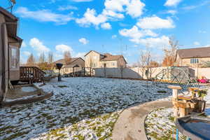 Yard covered in snow with a residential view and a fenced backyard