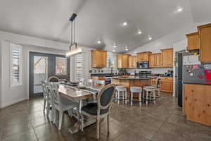 Dining space with recessed lighting, dark tile patterned flooring, and high vaulted ceiling