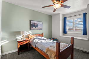 Bedroom featuring dark colored carpet and a ceiling fan