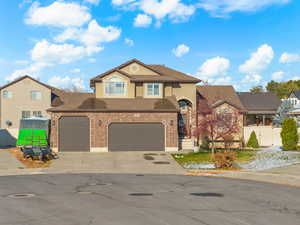 View of front of house featuring driveway, brick siding, an attached garage, and a shingled roof