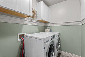 Laundry room featuring separate washer and dryer and cabinet space