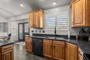 Kitchen with black appliances, dark stone counters, and dark tile patterned flooring