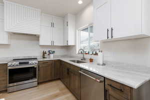 Kitchen featuring stainless steel appliances, white cabinets, and recessed lighting