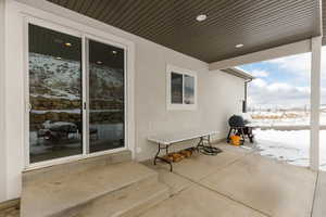 Snow covered patio featuring area for grilling