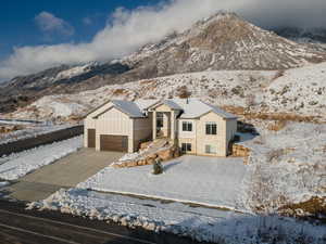 View of front of house featuring concrete driveway, board and batten siding, a garage, and a mountain view