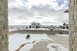 Yard covered in snow featuring a residential view