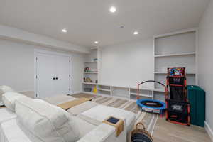 Game room with built in features, light wood-style flooring, and recessed lighting