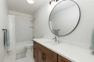 Full bathroom with shower / tub combo, vanity, and light marble finish floors