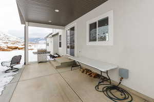 Snow covered patio featuring a patio and area for grilling