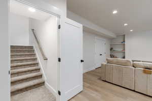 Interior space with recessed lighting, stairway, light wood-type flooring, and built in shelves