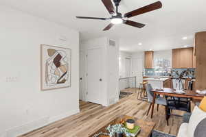Living room featuring light wood finished floors, a ceiling fan, and recessed lighting