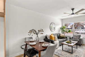 Dining room featuring ceiling fan, light wood-style flooring, and a textured ceiling
