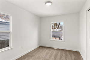Empty room with light carpet and baseboards