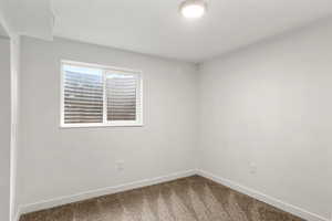 Unfurnished room featuring carpet floors and baseboards