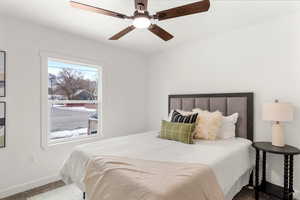 Carpeted bedroom featuring ceiling fan and baseboards