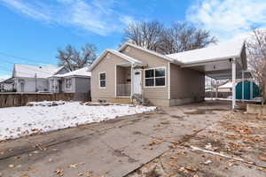 View of front of house featuring driveway, a carport, and a patio area