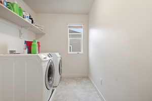 Laundry area featuring washing machine and dryer and window