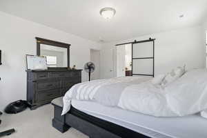 Master bedroom with a barn door and ensuite bathroom