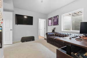 Carpeted office/bedroom featuring baseboards