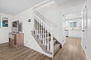 Stairway going to upper level with Lvp floors and baseboards