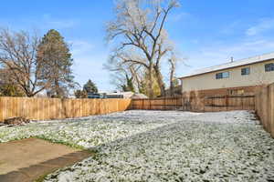 Yard covered in snow featuring a fenced backyard