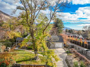View of front of house featuring a mountain view, a fenced front yard, and concrete driveway