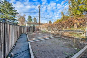 Fenced backyard with a vegetable garden