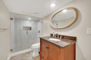 Bathroom featuring vanity, a shower stall, and light tile patterned floors