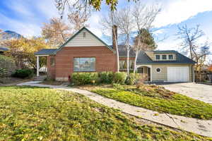 View of front of home featuring a front yard, concrete driveway, a garage, and brick siding