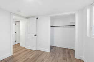 Unfurnished bedroom featuring light wood-style flooring and a closet