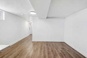 Finished below grade area with wood finished floors and a textured ceiling