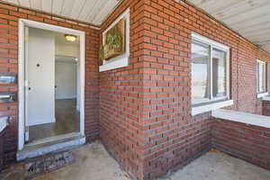 Entrance to property featuring brick siding