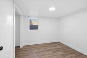 Basement with light wood-style flooring and baseboards