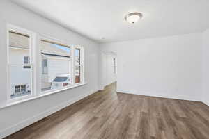 Unfurnished room featuring wood finished floors and a textured ceiling