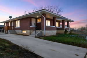 View of front of property with brick siding, a front yard, and concrete driveway