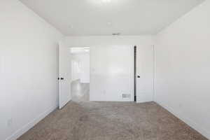 Empty room featuring light colored carpet and baseboards