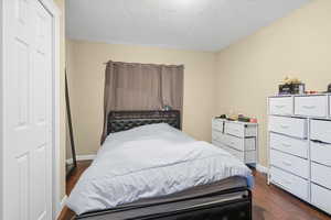 Bedroom with dark wood finished floors and a textured ceiling
