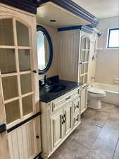 Bathroom featuring vanity, washtub / shower combination, and wood walls