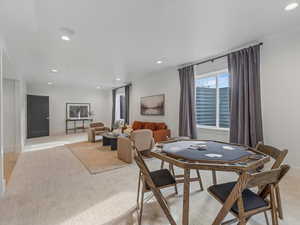Dining area with recessed lighting and light carpet