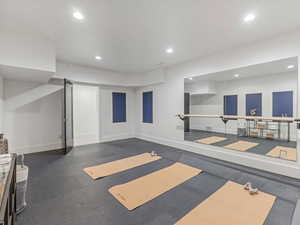 Workout area featuring recessed lighting and dark flooring