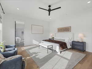 Bedroom with light wood-type flooring, ceiling fan, recessed lighting, and ensuite bathroom