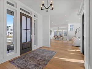 Entryway featuring a chandelier, light wood-style floors, and stairs